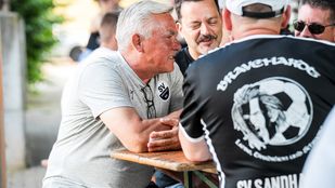 Chef-Trainer Olaf Janßen unterhält sich mit zwei Fans